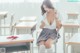 A woman sitting at a desk in a classroom.