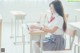 A woman sitting at a desk reading a book.