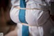 A woman in a white shirt and blue tie tied up to a rope.
