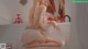a woman sitting on top of a bathtub next to a painting
