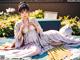 A woman in a kimono sitting on a green mat.