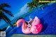 A woman laying on an inflatable flamingo in a swimming pool.