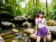 A woman in a purple skirt and white shirt standing in a stream.